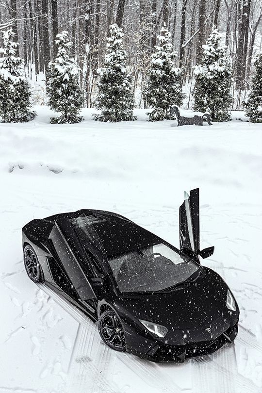 a black sports car is parked in the snow