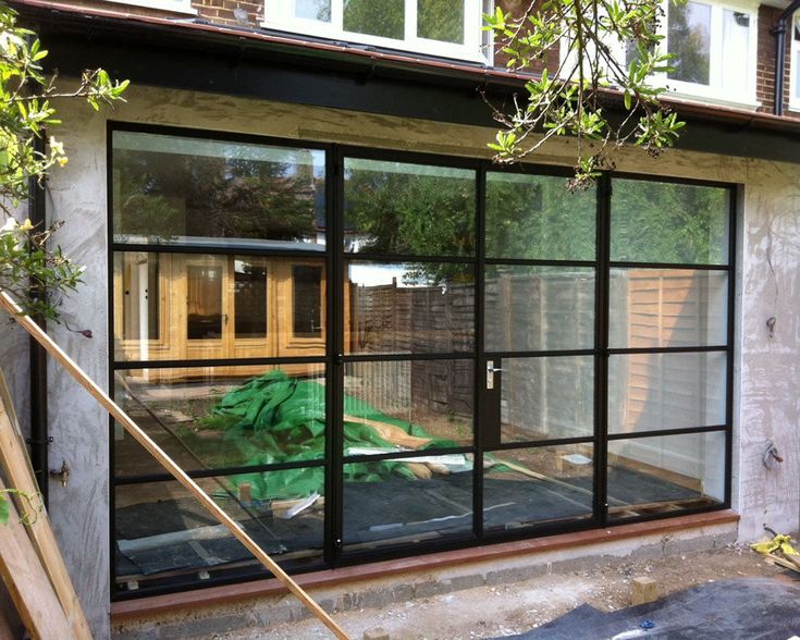 an outside view of a house with glass doors and plants in the window sill