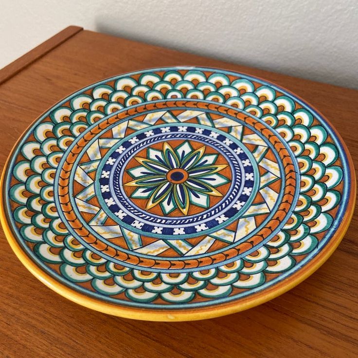 a colorful plate sitting on top of a wooden table