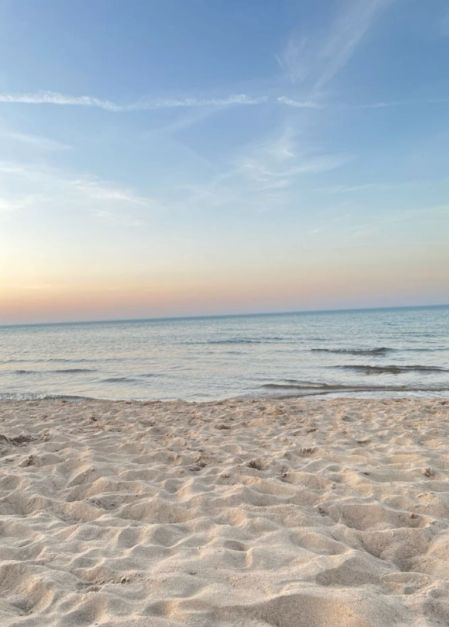 an empty beach with the ocean in the background