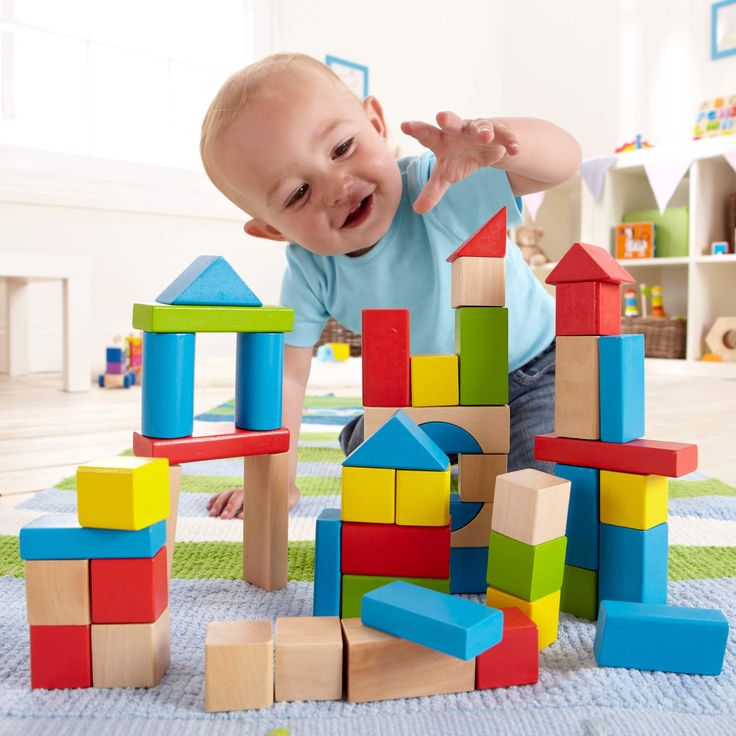 a baby playing with wooden blocks on the floor