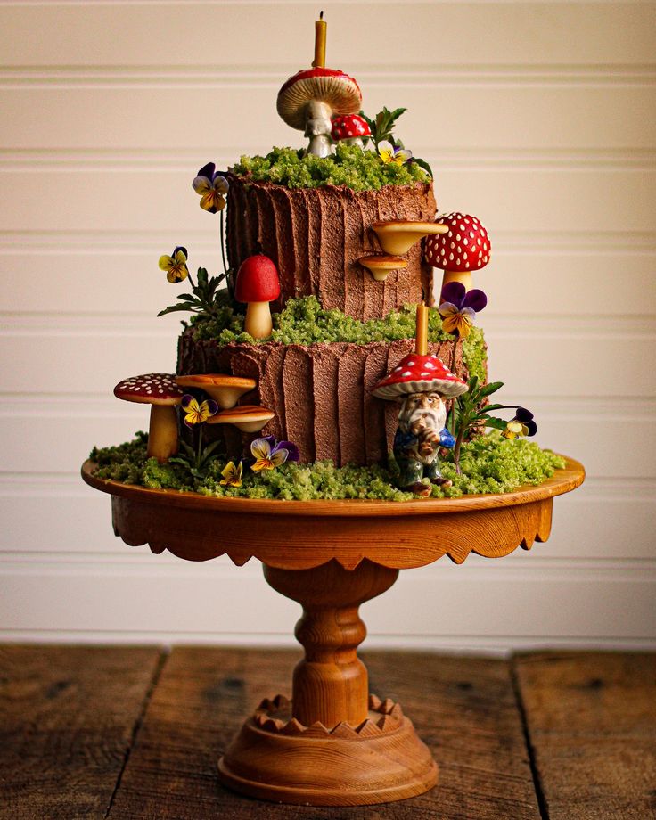 a three tiered cake decorated with mushrooms and moss