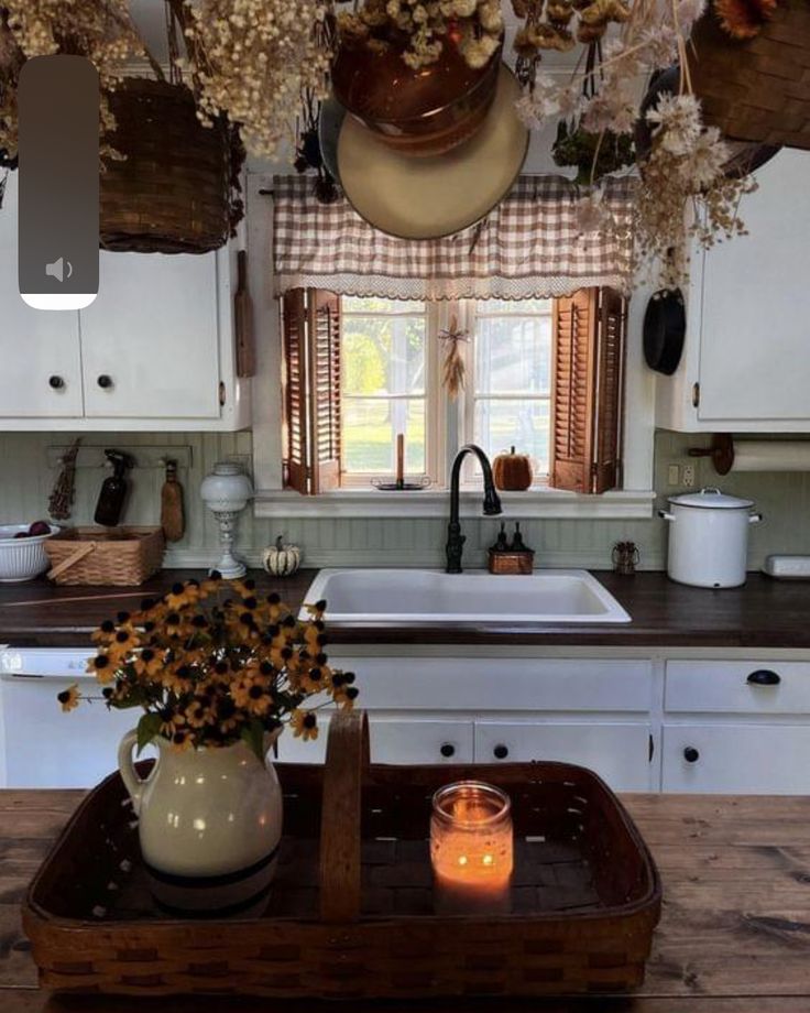 a kitchen filled with lots of white cabinets and counter top next to a wooden table