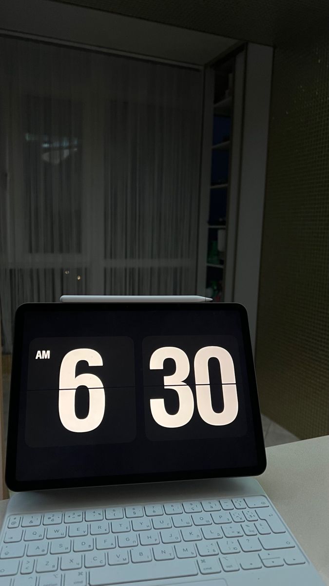 an alarm clock sitting on top of a laptop computer