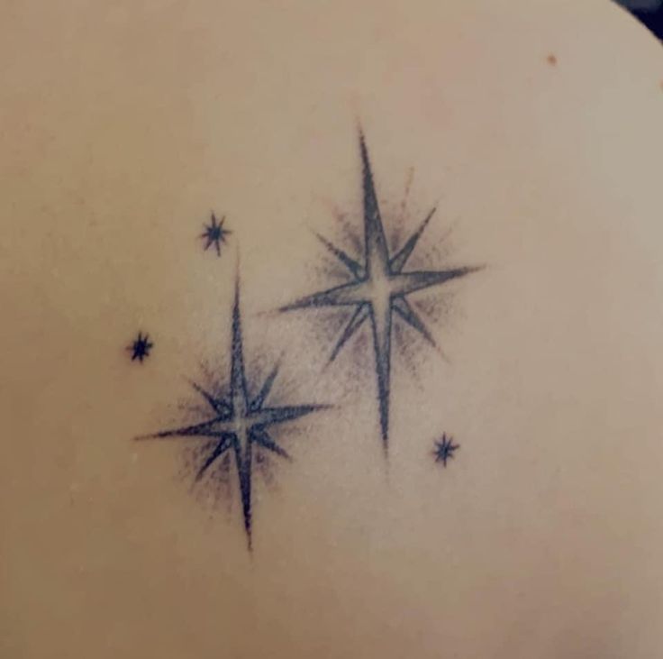 the back of a woman's shoulder with three stars on it