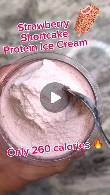 a person holding a spoon in front of a jar of ice cream with the words strawberry shortcake protein ice cream only 200 calories