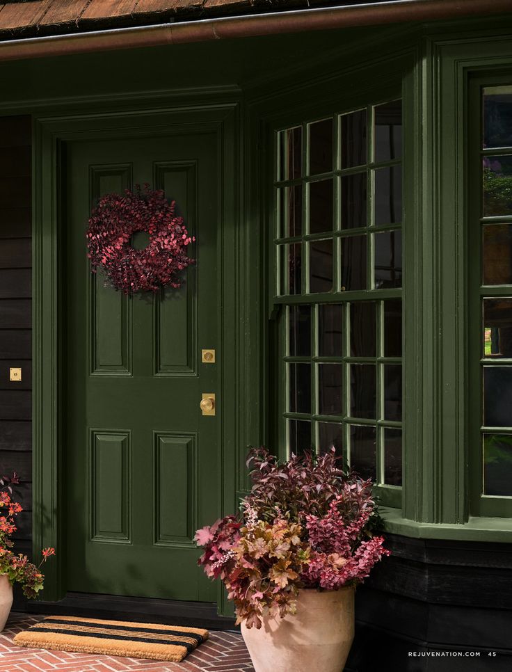 two planters with flowers in front of a green door