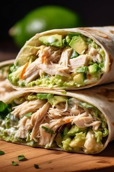 two wraps filled with chicken, avocado and cilantro on top of a wooden cutting board