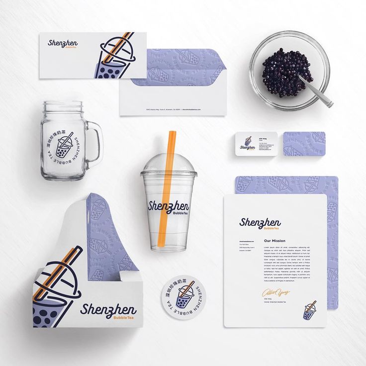 the stationery is laid out neatly on top of the table, including cups and business cards