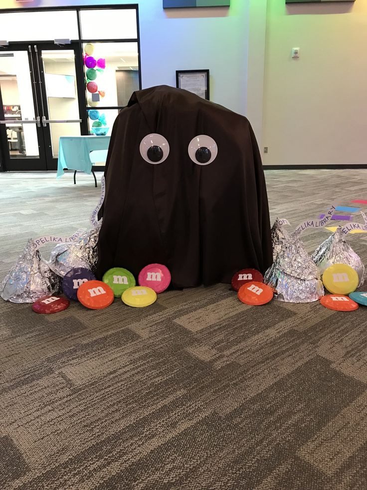 a black bag with eyes and candy on the floor