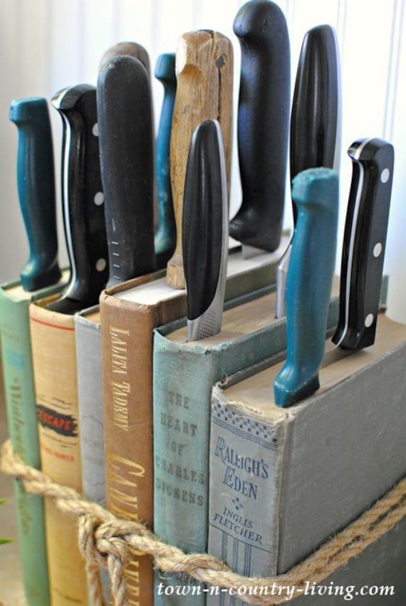 a bunch of books that are sitting on some kind of stand with knives in them