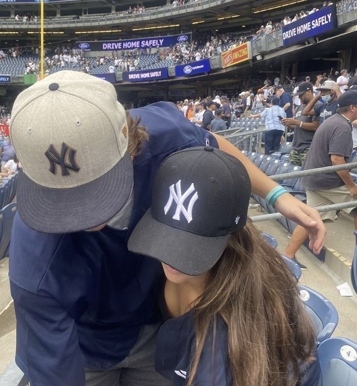 two baseball players hugging each other in the stands at a stadium with people watching them