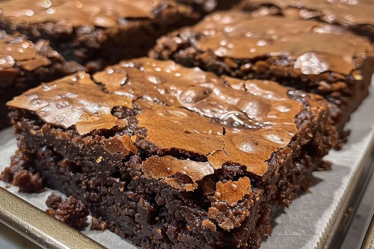 chocolate brownies with peanut butter frosting are on a baking sheet, ready to be eaten