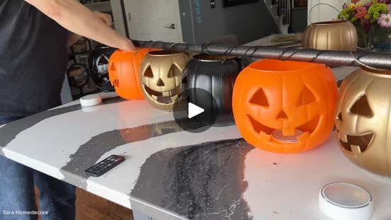 a man is decor pumpkins with headphones on the kitchen counter and phone in front of him