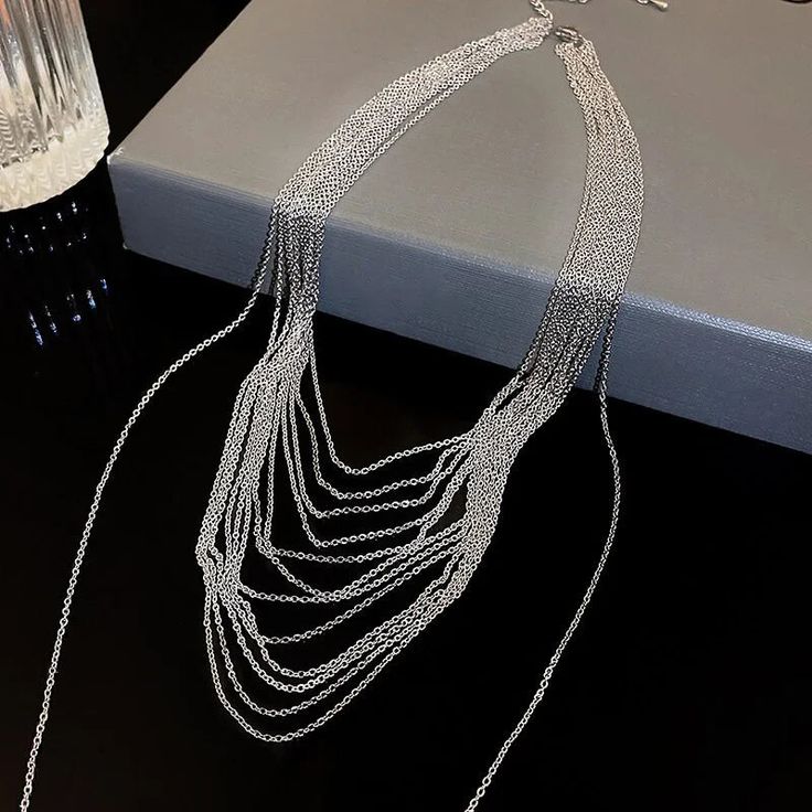 ✦ Transform your wardrobe with this Multistrand Silver Tassel Chain Necklace. Accessorize with this elegant yet simple piece for a bold and daring look. Perfect for a night out, this necklace will take your outfit to the next level. Despite the absence of diamonds, this eye-catching piece will make you shine at any party! ----------- DETAILS ----------- - Color: Silver - Materials: Brass - Necklace Length: 42.3cm - SKU: HN2699 Long Necklace With Adjustable Chain For Party, Silver Chain Long Necklace For Party, Party Long Necklaces With Adjustable Chain, Party Long Necklace With Adjustable Chain, Trendy Silver Jewelry For Night Out, Elegant Silver Chain Necklace For Party, Adjustable Chain Choker Necklace For Party, Minimalist Chain Necklace For Evening, Delicate Metal Chain Necklace For Evening