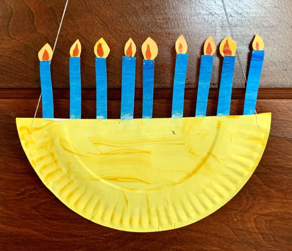 a yellow paper plate with blue candles on it