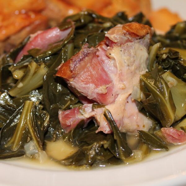 a white plate topped with meat and greens