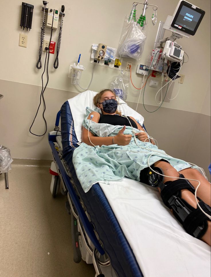 a woman laying in a hospital bed with an oxygen mask on