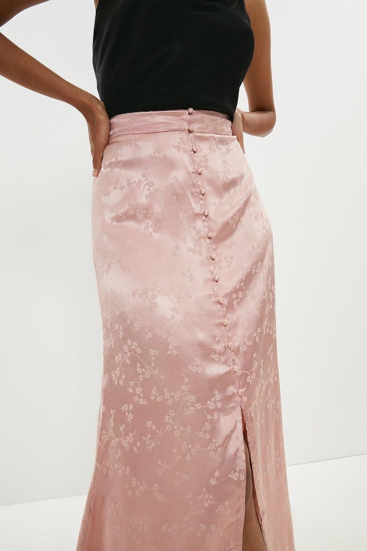 Borrowing from vintage styles, this silky satin midi skirt is at once both feminine and refined. Its tonal floral pattern and fabric-covered buttons add a romantic touch to this fluid, flirtatious design.Style: Midi SkirtFabric: SatinLength: Midi Pink Silk Skirt, Skirts Satin, Satin Skirts, Latest Skirts, Satin Midi Skirt, Fabric Covered Button, Satin Skirt, Pink Skirt, Boutique Brands