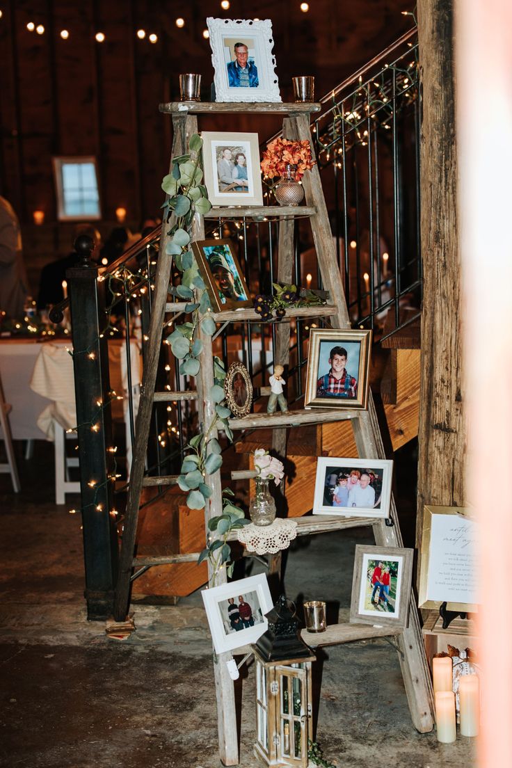 an old ladder is decorated with pictures and candles for a rustic wedding or anniversary party