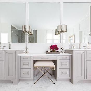 a white bathroom with two sinks, mirrors and stools in front of the vanity