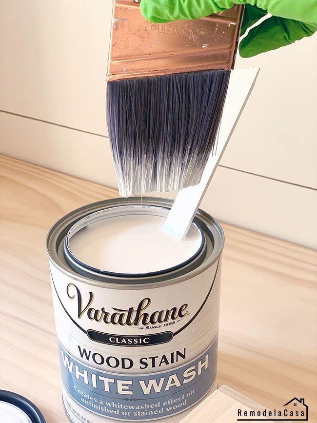 a paint can being dipped with wood stain