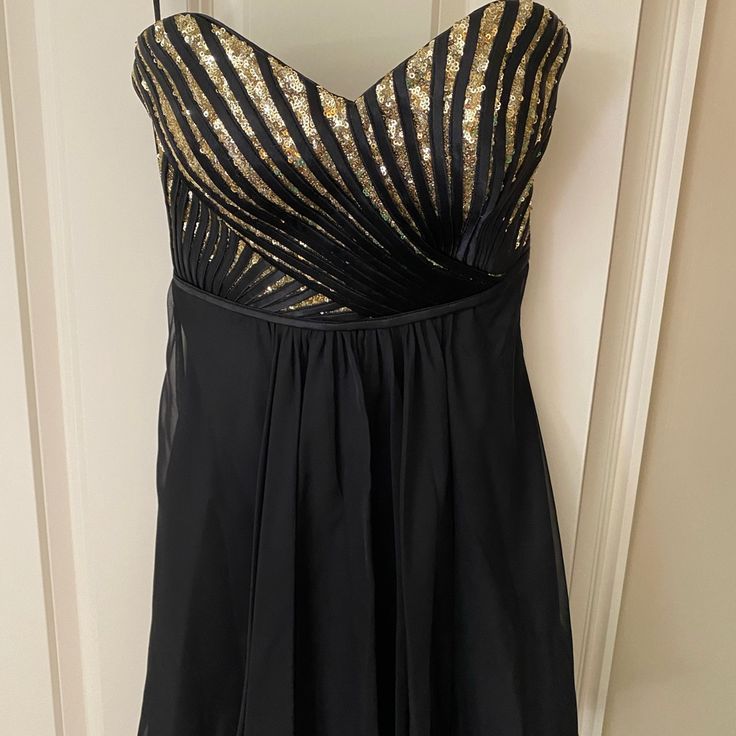 a black dress with gold sequins on it