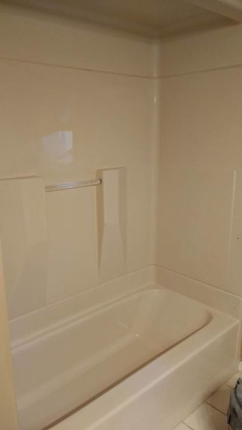 a white bath tub sitting inside of a bathroom next to a toilet paper dispenser