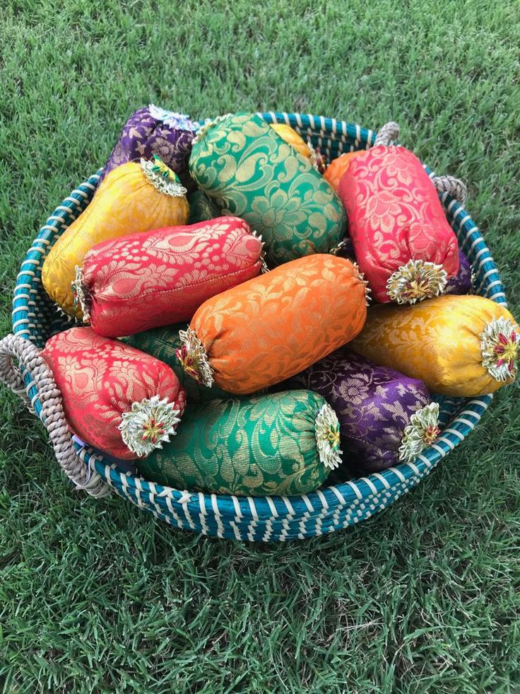 a basket filled with colorfully decorated eggs on top of green grass in the grass