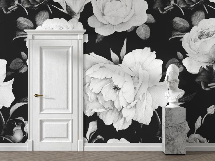 an open door in front of a black and white wallpaper with flowers on it