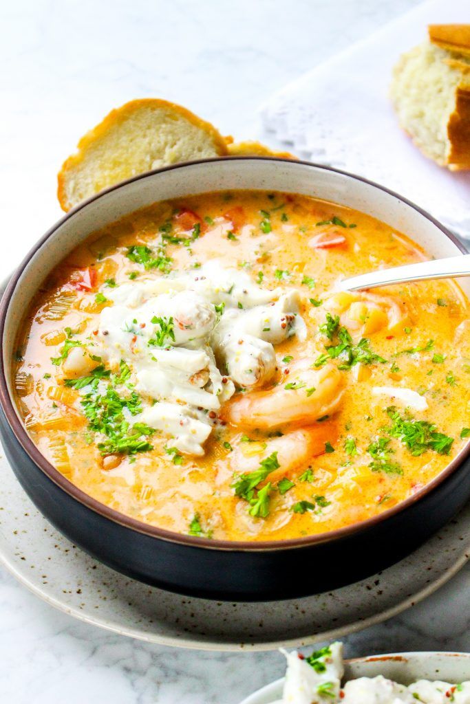 a bowl of soup on a plate with bread