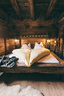 a bed in a room with wooden walls and flooring that is made out of wood planks