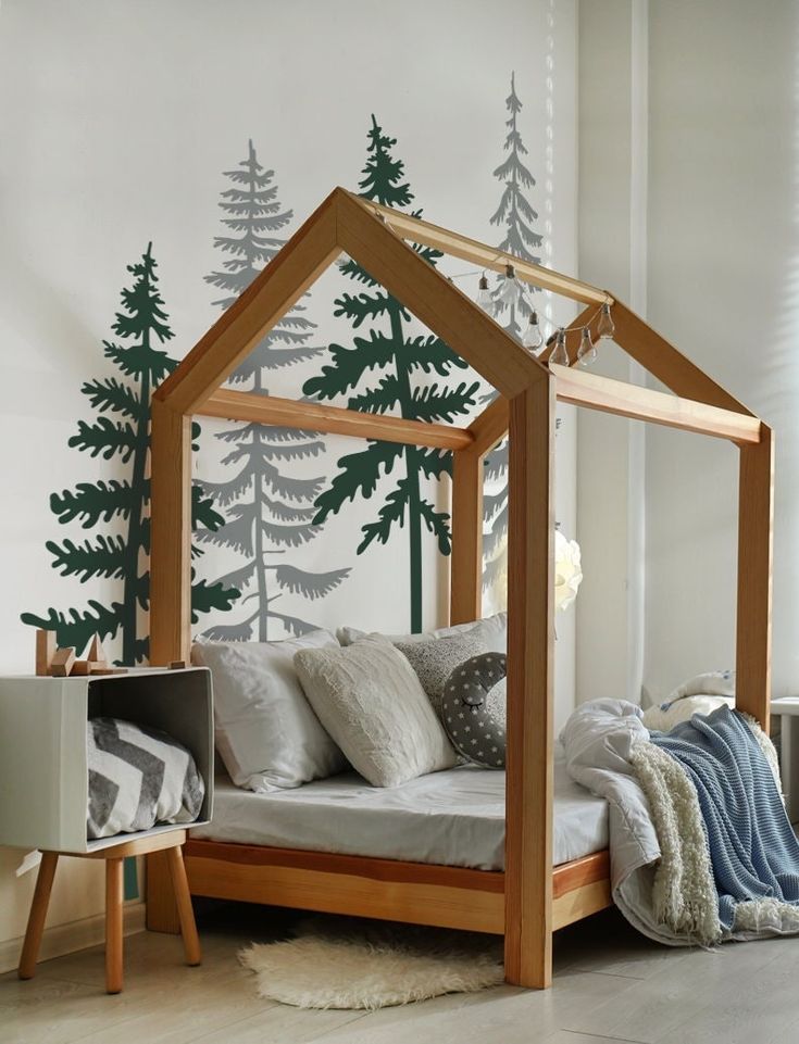 a bedroom with a canopy bed and trees painted on the wall