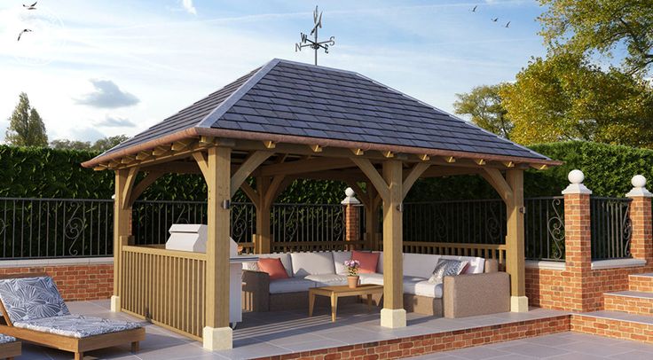 a wooden gazebo sitting on top of a patio next to a brick wall and fence