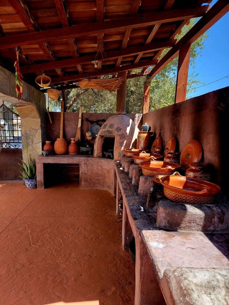 an outdoor kitchen with pots and pans on the stove