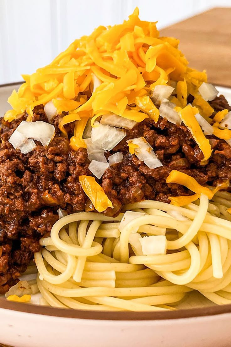 a plate of spaghetti with meat and cheese on top