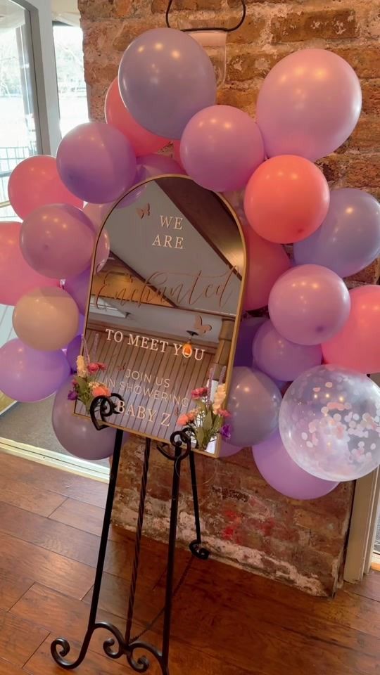 a mirror that is on top of a stand with balloons in the shape of a heart