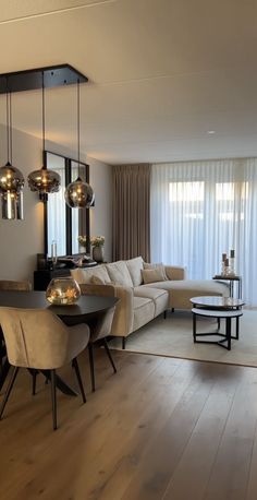 a living room filled with furniture next to a large window covered in sheer drapes