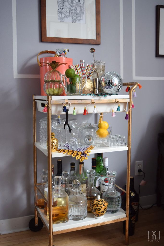 a bar cart filled with liquor bottles and glasses