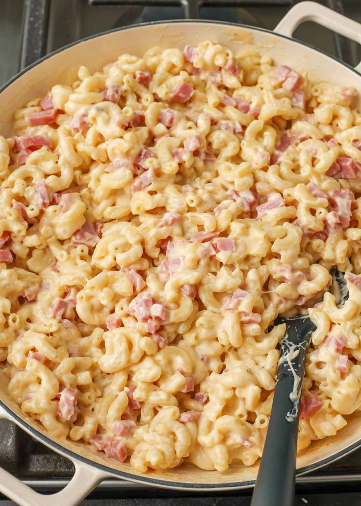 a pan filled with macaroni and cheese on top of a stove