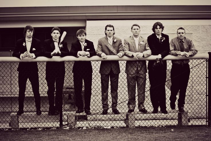 a group of men standing next to each other near a fence