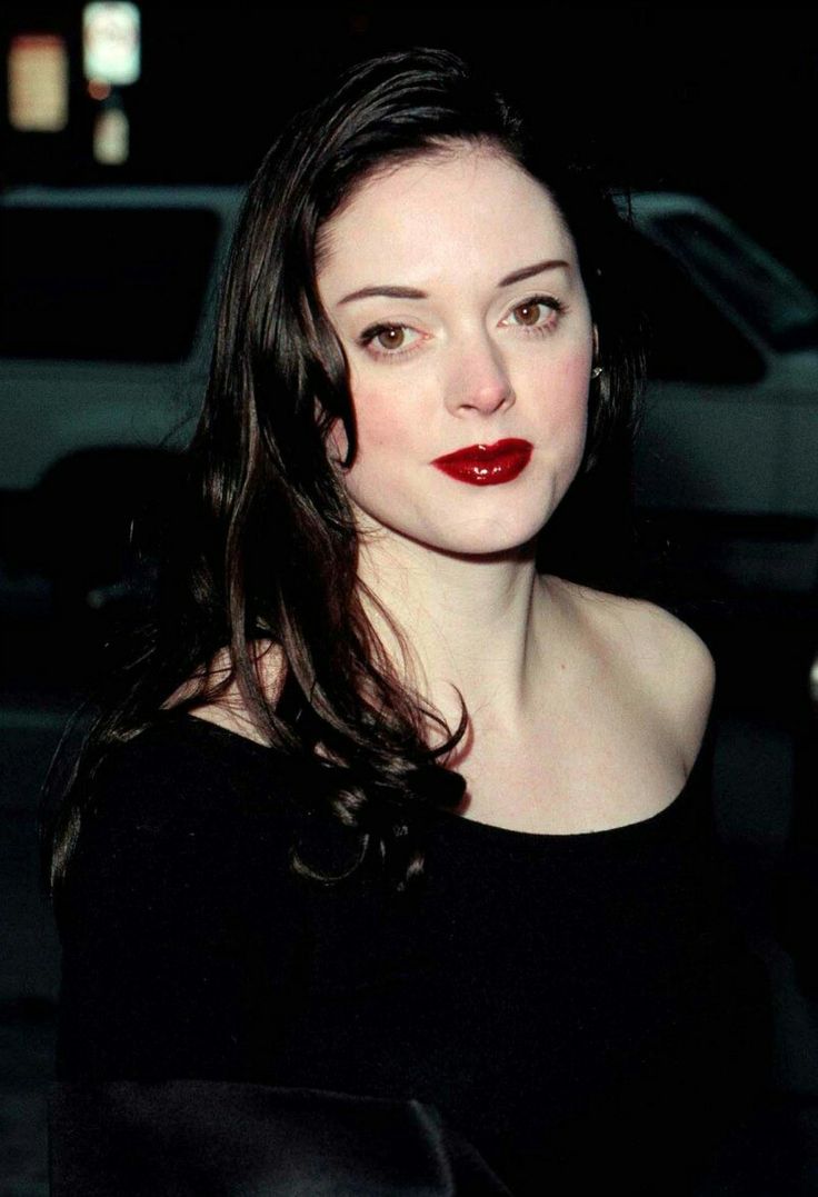 a woman with long dark hair and red lipstick