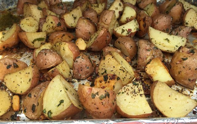 cooked potatoes with herbs and seasoning on tin foil