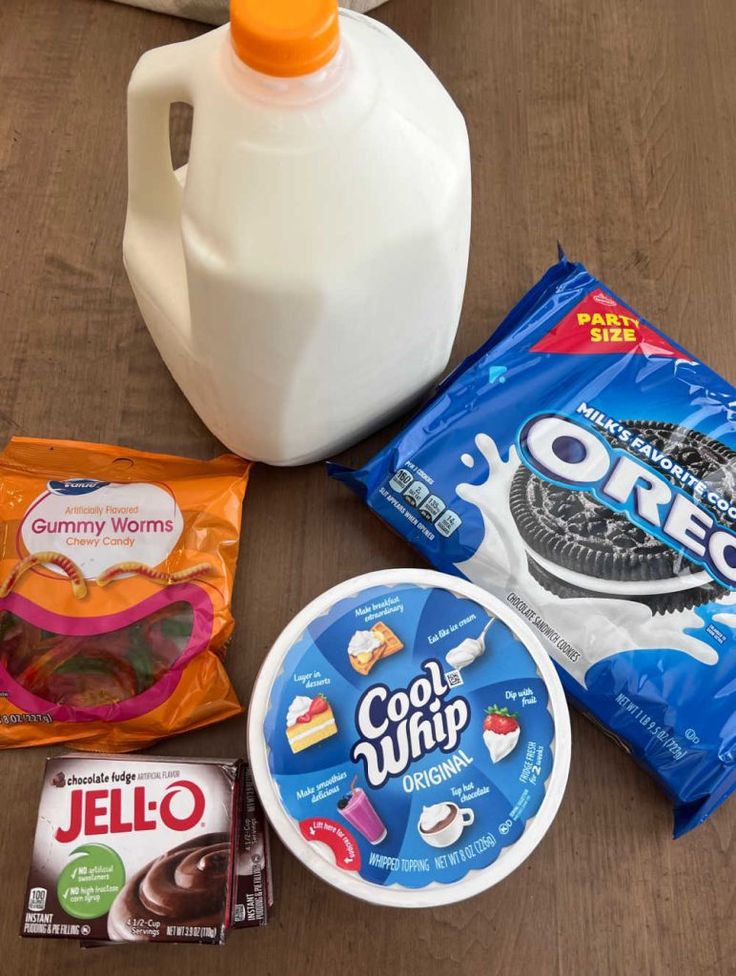 the ingredients to make an ice cream sandwich laid out on a wooden table next to a jug of yogurt