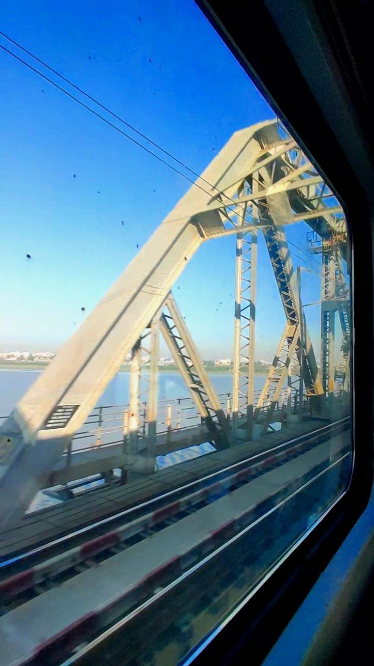 a train traveling over a bridge next to the ocean