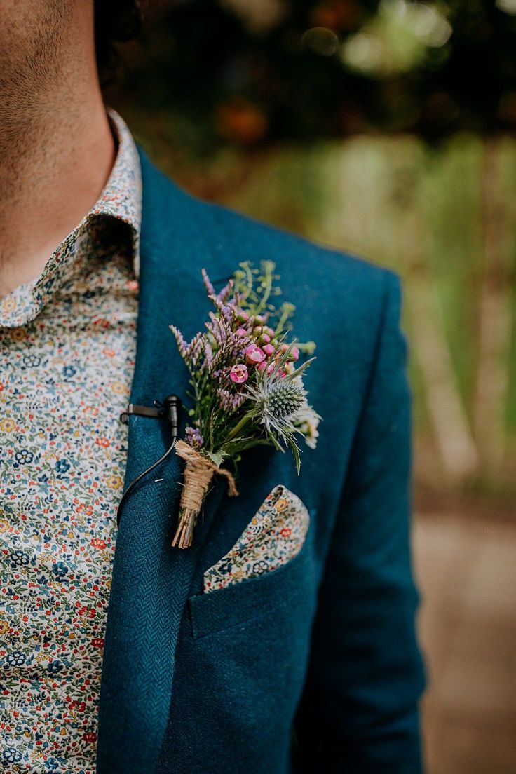 a man wearing a blue suit and flower boutonniere