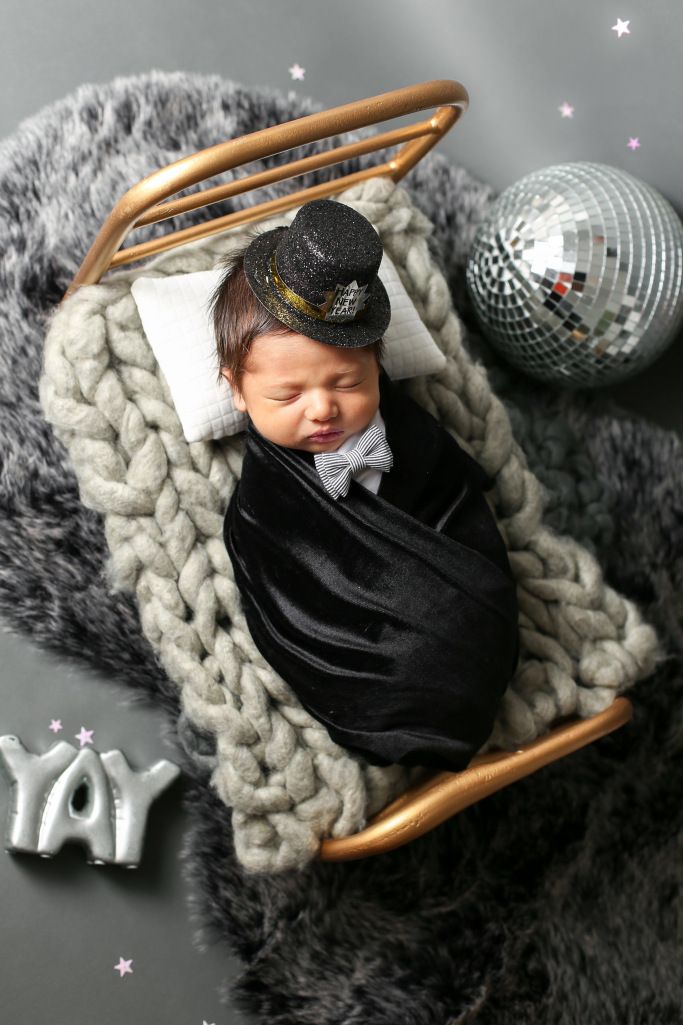 a baby is sleeping in a sleigh with a hat on