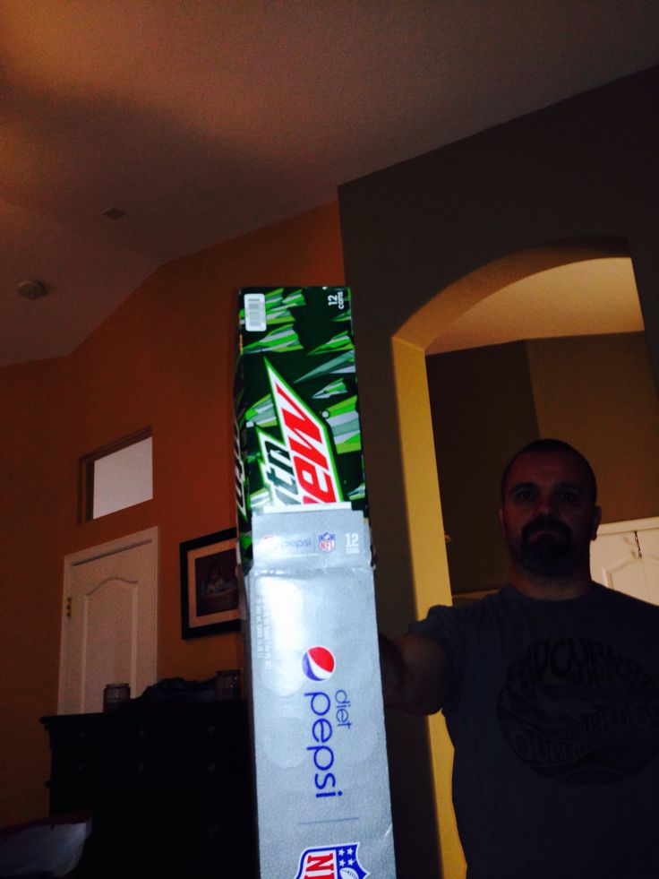 a man standing next to a soda box