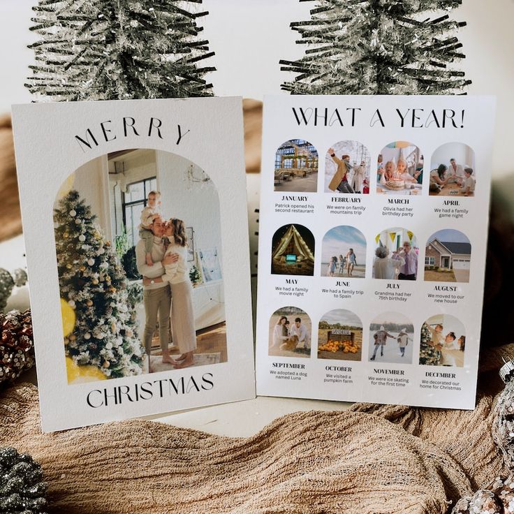 two christmas cards sitting on top of a table next to pine cones and fir trees