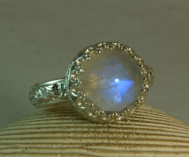 Faceted blue Moonstone Ring set in solid sterling silver with a fancy filigree bezel setting. To wear this moonstone ring is to capture a flash of moonlight on your finger, a stolen bit of lunar rainbow. There is something mystical about the way the stone shines on your finger, encircled in a crown of silver hearts and held by a band of etched, twining vines. This listing is for a handmade .925 sterling silver natural moonstone ring. I have three of these beautiful stones available for custom wo Gothic Engagement Ring, June Birthstone Ring, Moonstone Ring Sterling Silver, Princess Ring, Moonstone Engagement, Moonstone Engagement Ring, Blue Moonstone, Rainbow Moonstone Ring, June Birthstone